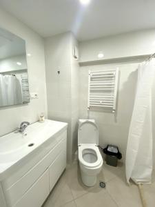 a white bathroom with a toilet and a sink at GSS - B Apartment in Tbilisi City