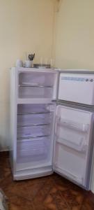 an empty refrigerator with its door open in a kitchen at Apartamentos Centricos Puerto Iguazu in Puerto Iguazú