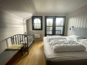 ein Schlafzimmer mit 2 Betten und einem Kinderbett in der Unterkunft Bakkebyvegen 20A in Trysil