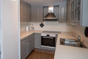 a kitchen with a sink and a stove top oven at Bakkebyvegen 20A in Trysil