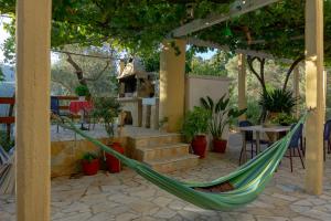 een hangmat op een patio met een tafel en stoelen bij Cottage home at South Chania in Grigorianá