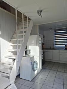 una cocina con nevera blanca y una escalera en De Juttershut, en Egmond aan Zee
