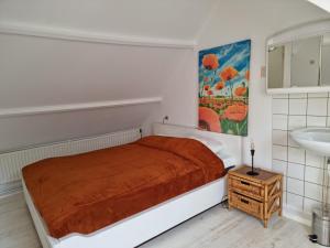 Dormitorio pequeño con cama y lavamanos en De Juttershut, en Egmond aan Zee