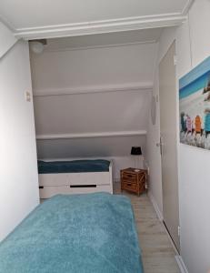 Habitación pequeña con cama y alfombra azul en De Juttershut, en Egmond aan Zee