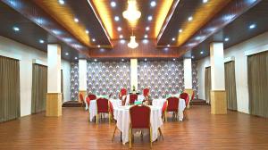 a banquet hall with tables and red chairs in it at ShriGo Hotel Gangtok in Gangtok