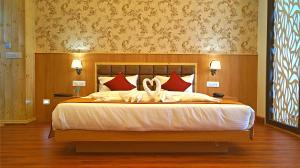 a bedroom with a large bed with red pillows at ShriGo Hotel Gangtok in Gangtok
