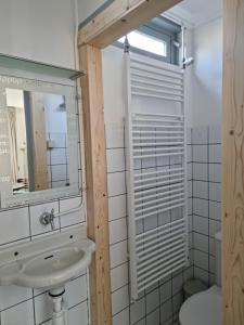 y baño con lavabo y espejo. en De Juttershut, en Egmond aan Zee