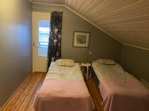2 łóżka pojedyncze w pokoju z oknem w obiekcie Villa Toivo w mieście Rovaniemi
