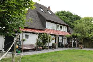赫魯特的住宿－Hoeve te Gast - vakantieboerderij，白色的小房子,带有茅草屋顶