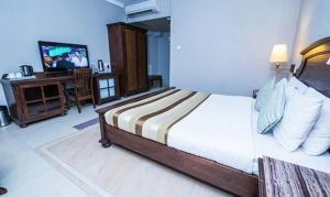 a bedroom with a bed and a television in it at FabHotel Prime Neelam The Glitz in Calangute