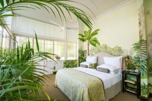 a bedroom with a bed and some plants at Dorp Hotel in Cape Town