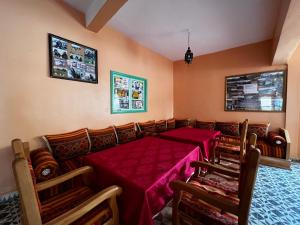 ein Esszimmer mit einem roten Tisch und Stühlen in der Unterkunft Hotel Izlane in Imilchil