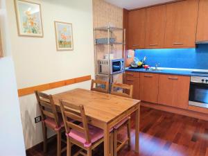 eine Küche mit einem Holztisch und Stühlen in der Unterkunft Apartamento Kerkus Alba in Villanúa