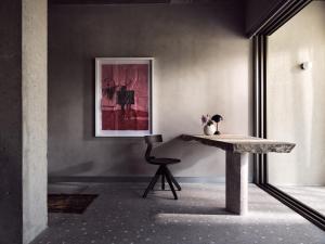 a table and a chair in a room with a picture at Ekies All Senses Resort, a Member of Design Hotels in Vourvourou