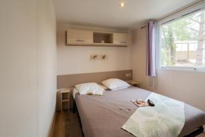 a small bedroom with a bed and a window at Camping Sunelia L'Argentière in Cogolin +57 photos