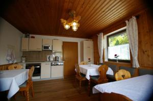 eine Küche und ein Esszimmer mit 2 Tischen und einem Fenster in der Unterkunft Haus Brigitte Rettensteiner in Schladming