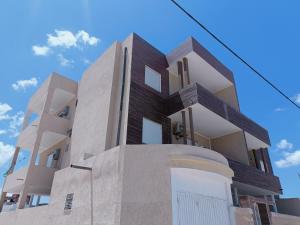 a tall building with a blue sky in the background at Family house in Ḩammām al Ghazzāz