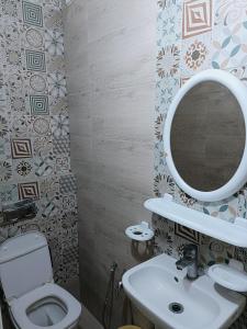 a bathroom with a toilet and a sink and a mirror at Family house in Ḩammām al Ghazzāz