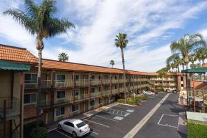 ariaal uitzicht op een hotel met palmbomen en een parkeerplaats bij Super 8 by Wyndham Anaheim/Disneyland Drive in Anaheim