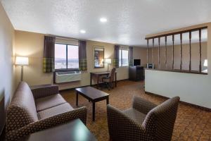 a living room with chairs and a table and a desk at Super 8 by Wyndham Summersville in Summersville