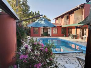 a house with a swimming pool in a yard at Pousada Vila D' Itália in Penha