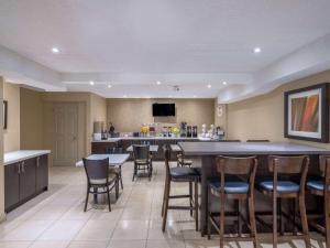 a large room with a bar and some chairs at Super 8 by Wyndham Toronto East ON in Toronto