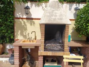 cocina al aire libre con fregadero y chimenea en Chalet entre parques naturales, en Vallgorguina