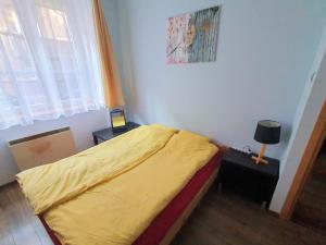 1 dormitorio con 1 cama con edredón amarillo en Basic, quiet apartment close to Main Square en Cracovia