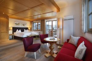 pokój hotelowy z łóżkiem, stołem i krzesłami w obiekcie Hotel Petersboden w Lech am Arlberg