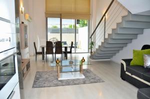 a living room with a glass table and a staircase at Oshun Madrid Norte LOFTS & MIDSTAY in Madrid