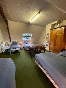 a bedroom with three beds and a table and chairs at Vacances paradisiaques au coeur de l'Ile de Bréhat in Bréhat