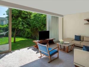 a living room with a blue chair and a television at Club Prive By Rixos Belek in Belek