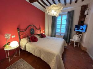 una camera rossa con letto e TV di San Giorgio Suite a Pisa Altre 16 foto
