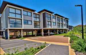 un bâtiment avec un parking en face de celui-ci dans l'établissement Zimbali Lakes Boulevard Suites 256, à Durban