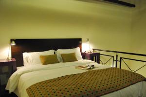 a bedroom with a large bed with two lamps at La Rozada Suites in Corrientes