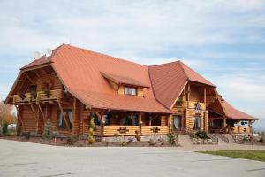 una grande casa in legno con tetto rosso di Székelyföld Fogadó a Borzont