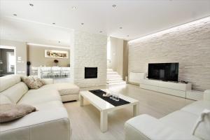 een woonkamer met witte meubels en een stenen muur bij Villa Alex Exclusive in Poreč