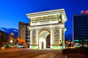 a building with an arch in a city at night at Skopje Rekord Ivan Apartment in Skopje