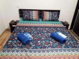 a bed with two blue pillows on it at Skopje Rekord Ivan Apartment in Skopje