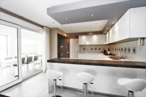 een keuken met witte krukken en een groot raam bij Villa Alex Exclusive in Poreč