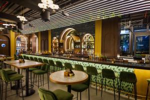 a bar with green chairs and tables in a restaurant at Radisson Beach Resort Palm Jumeirah in Dubai