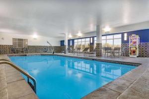 a large swimming pool with blue water in a building at AmericInn by Wyndham International Falls in International Falls