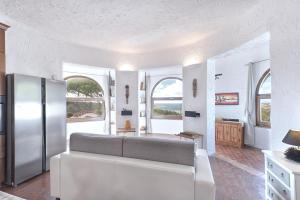 イーゾラ・ロッサにあるヴィラ イーゾラ ロッサの白い壁と窓のあるキッチン、冷蔵庫が備わります。