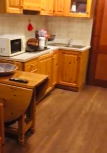 a kitchen with wooden cabinets and a counter top at Monolocale la terrazza sulla neve-Cervinia in Breuil-Cervinia +8 photos