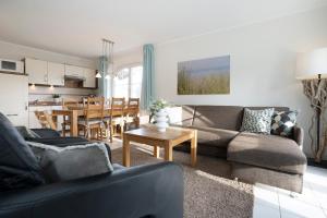 - un salon avec un canapé et une salle à manger dans l'établissement Haus Pegasus App 4, à Scharbeutz
