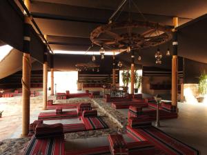 a lobby with a bunch of tables and chairs at Sinam Desert Resort in Wadi Rum