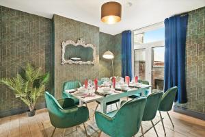a dining room with a table and green chairs at Central Free Parking Luxury House in Oxford