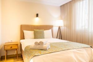Una habitación de hotel con una cama con toallas. en Colorful and Central Flat near Kulturpark Izmir, en Izmir