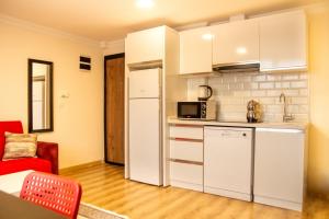 a kitchen with a white refrigerator and a red chair at Colorful and Central Flat near Kulturpark Izmir in Izmir
