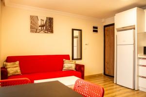 a living room with a red couch and a table at Colorful and Central Flat near Kulturpark Izmir in Izmir